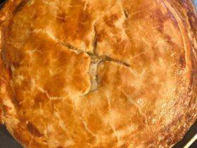Homemade chicken pot pie with flaky crust, creamy chicken filling, carrots, peas, and celery