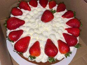 Homemade strawberry shortcake topped with whipped cream and fresh strawberries
