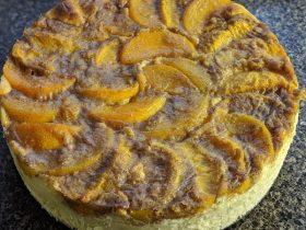 Peach cobbler cheesecake with creamy layers, cinnamon peaches, and golden cobbler topping