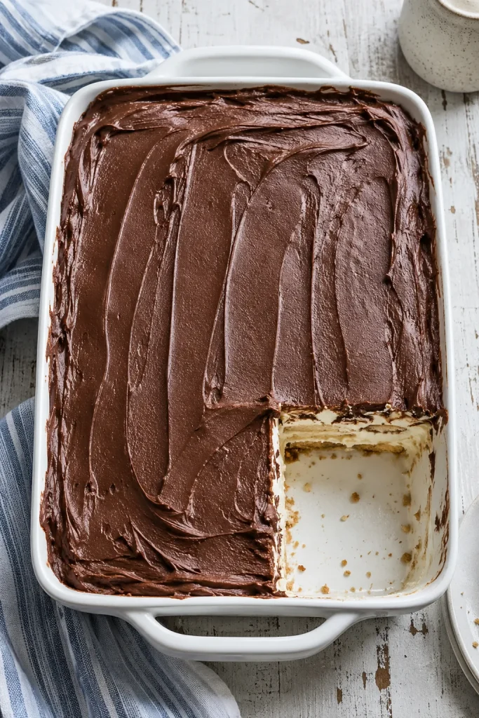slice of no-bake chocolate eclair cake with creamy vanilla layers and chocolate frosting