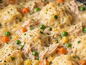 Finished Crockpot Chicken and Dumplings in a slow cooker with creamy broth and biscuit dumplings
