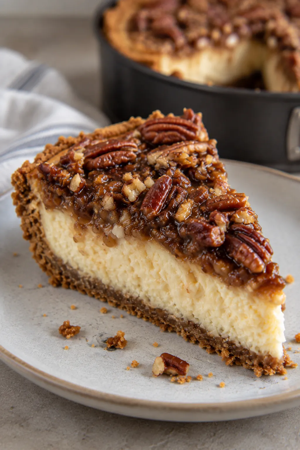 Slice of pecan cheesecake pie with caramel pecan topping