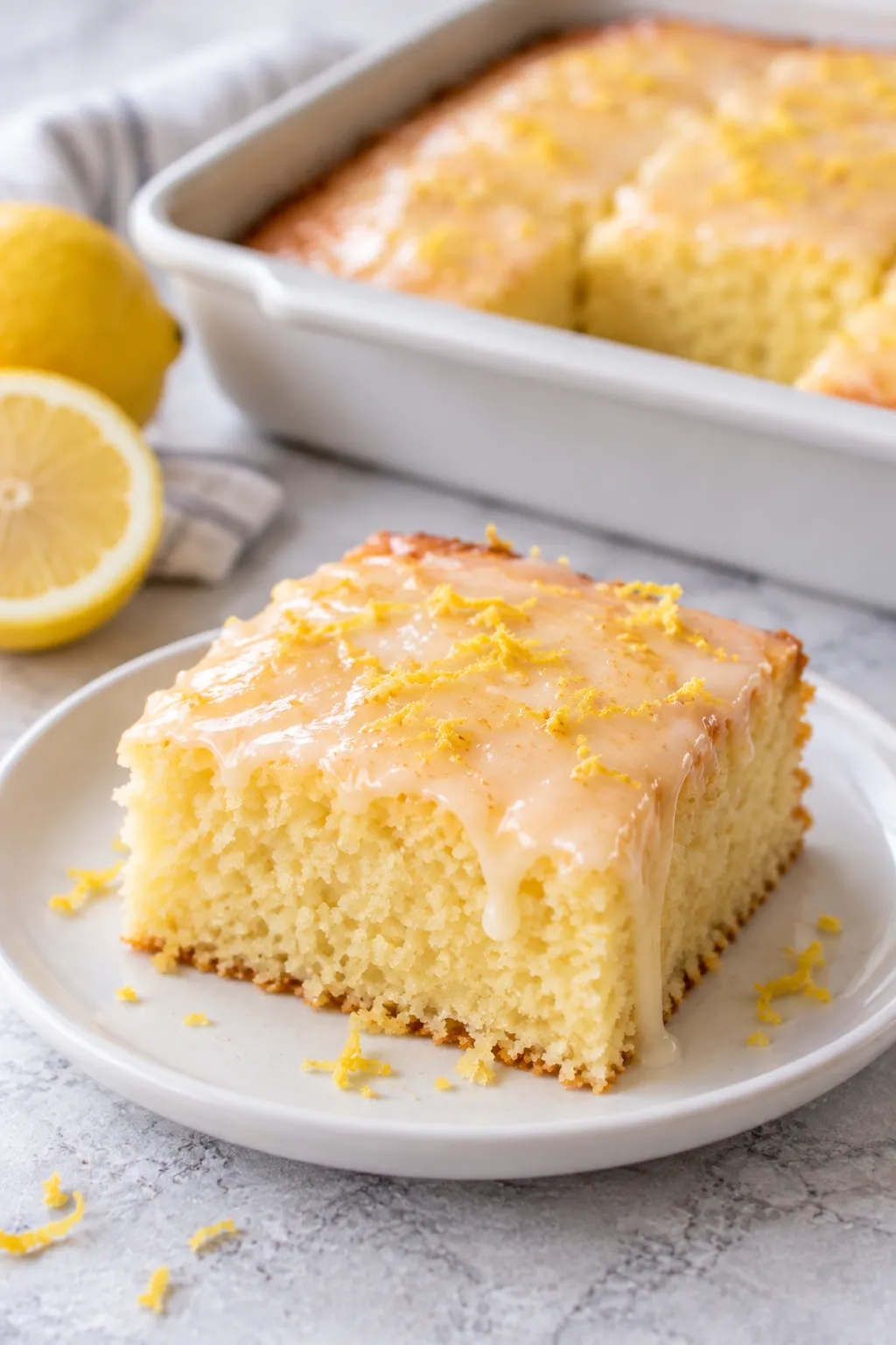 Plated slice of Lemon Cake To Die For with lemon glaze and zest