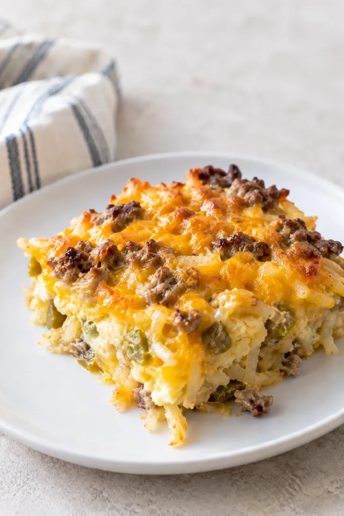 Plated slice of cheesy sausage hash brown breakfast casserole