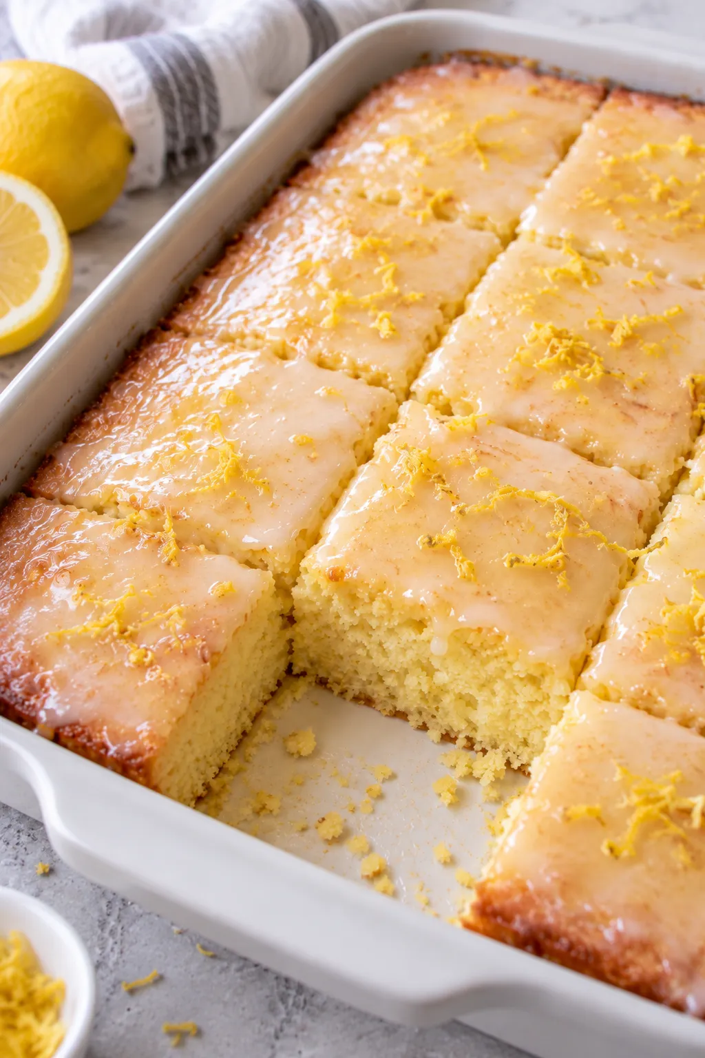 Glazed Lemon Cake To Die For cut into squares in a baking dish