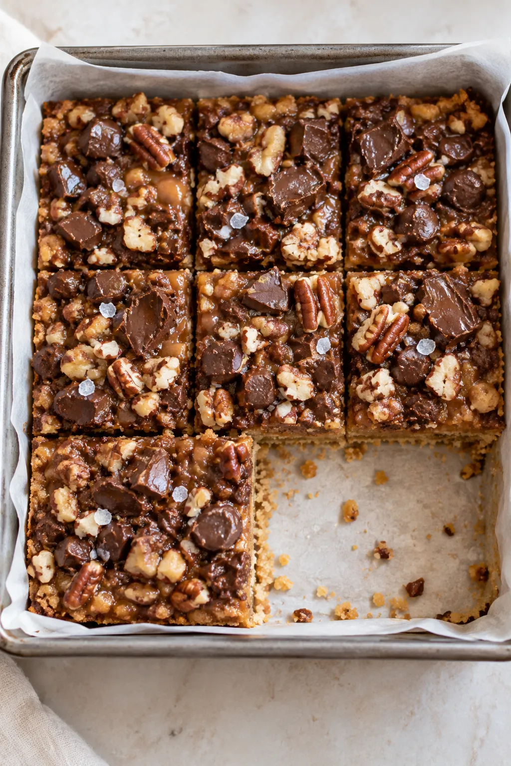 Close-up of gooey Caramel Chocolate Crunch Bars with semi-sweet chocolate and nuts