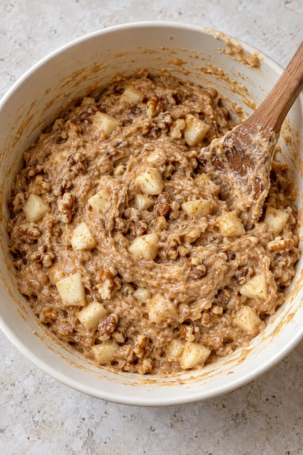Chopped apple and walnuts folded through thick cinnamon cake batter