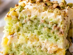 Slice of pistachio pineapple cake with fluffy pistachio frosting and chopped pistachios