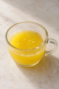 Melted unsalted butter in a small clear glass cup