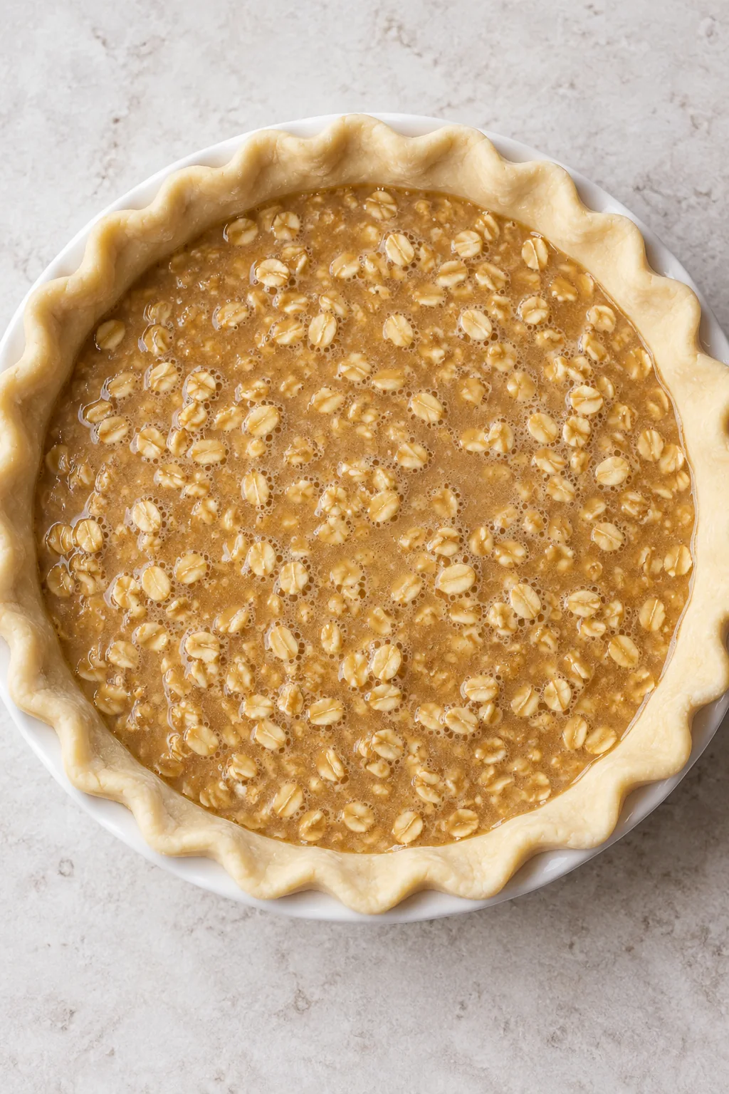 Raw oatmeal pie filling poured into an unbaked pastry shell before baking