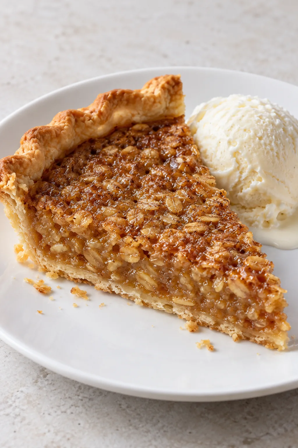 A slice of Amish oatmeal pie with a small scoop of optional vanilla ice cream