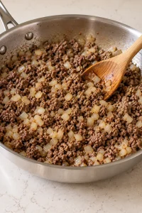 Browned ground beef and diced onion in the skillet before adding marinara.