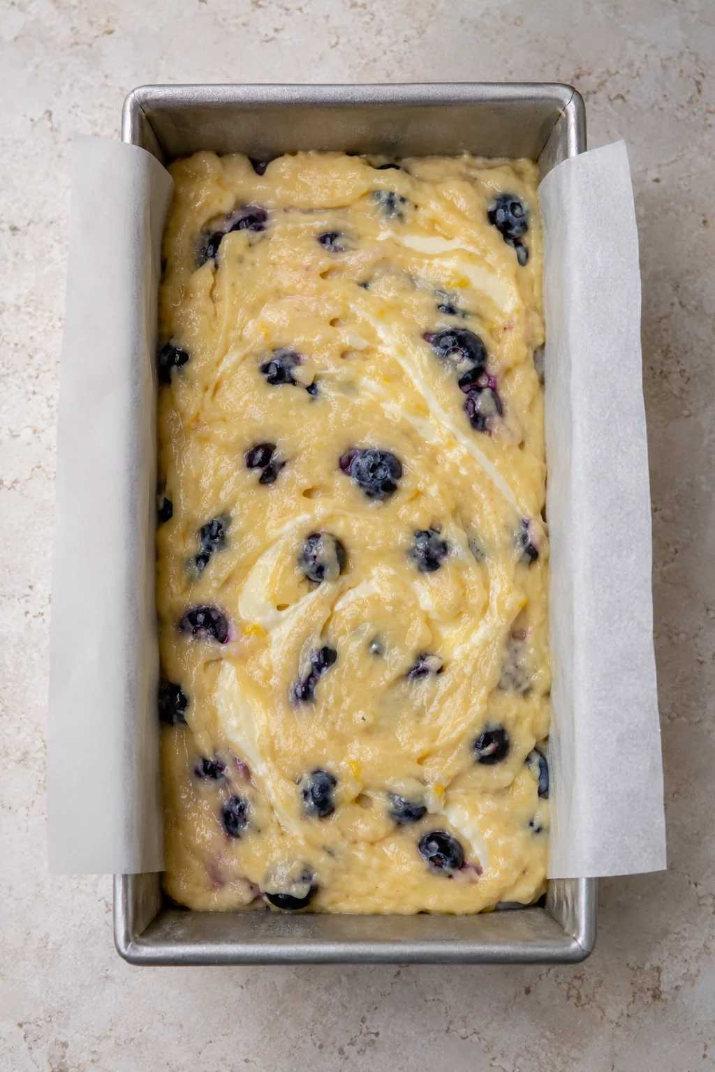 Top layer of blueberry batter with a gentle cream cheese swirl before baking