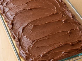 Whole Boston cream poke cake with chocolate frosting in a glass baking dish
