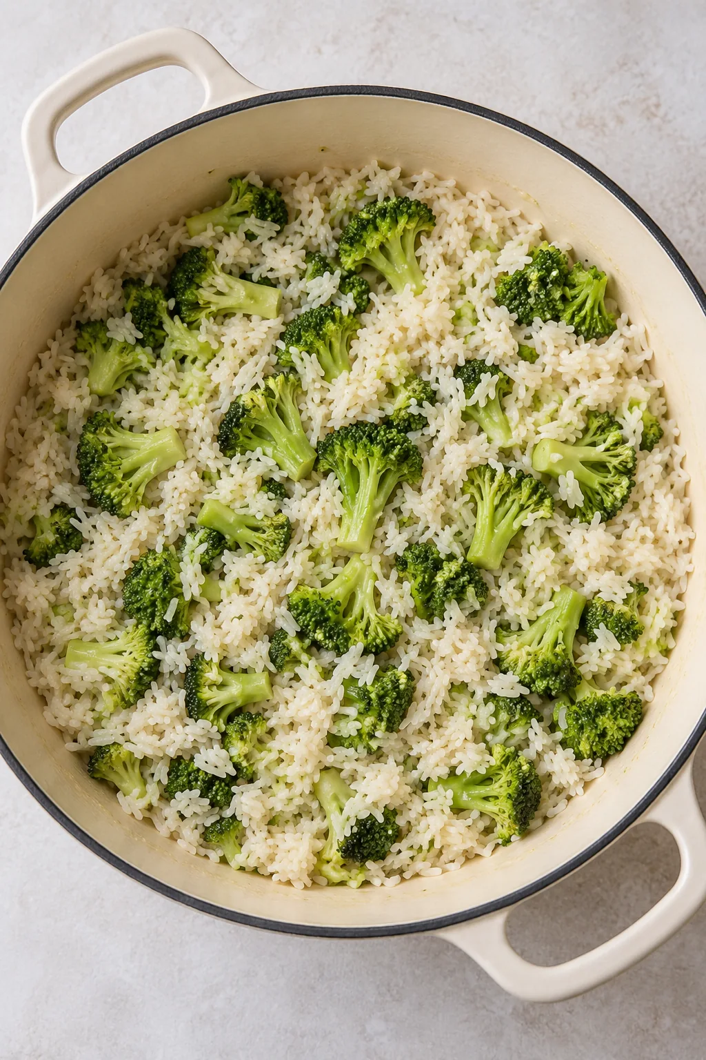 Tender long-grain rice and cooked broccoli florets in the pot before the creamy filling is mixed