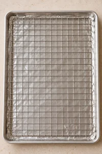 Oven-safe wire rack set over a foil-lined rimmed baking sheet before coating the pretzels