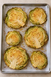 Cabbage steaks after the first roast, with softened centers and lightly browned edges before adding Parmesan