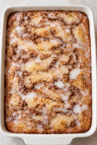 Thin vanilla glaze spread over the baked cinnamon swirl cake