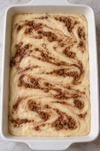 Brown cinnamon ribbons gently swirled through raw vanilla cake batter