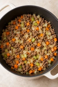 Diced onion, carrots and celery softened with browned ground beef.