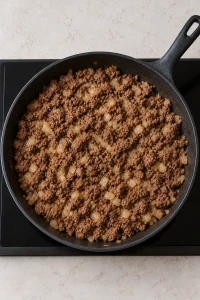 Browned ground beef and softened diced onion in a deep skillet