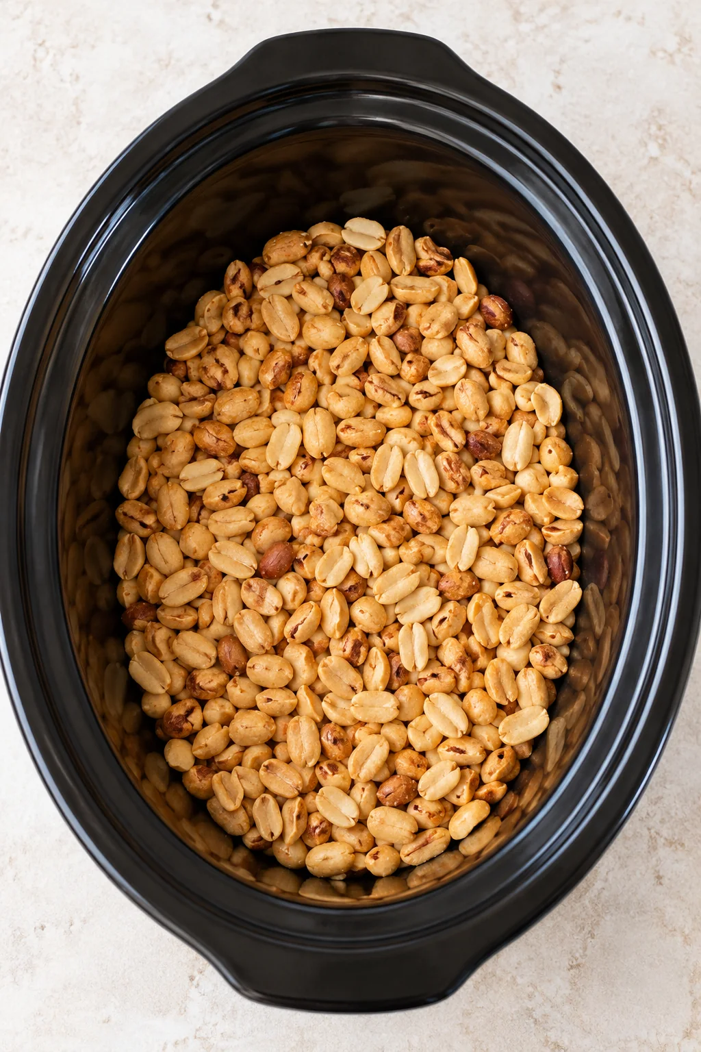 Salted and unsalted peanuts spread across a slow-cooker insert