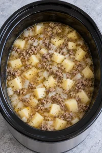 Chicken broth and dried herbs stirred into the beef and potatoes.