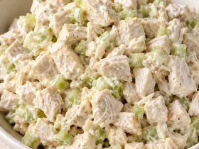 Creamy diced chicken salad with small pieces of celery in a white bowl