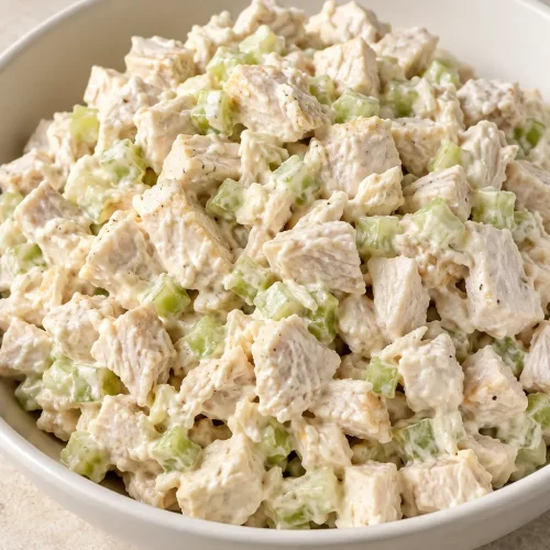 Creamy diced chicken salad with small pieces of celery in a white bowl