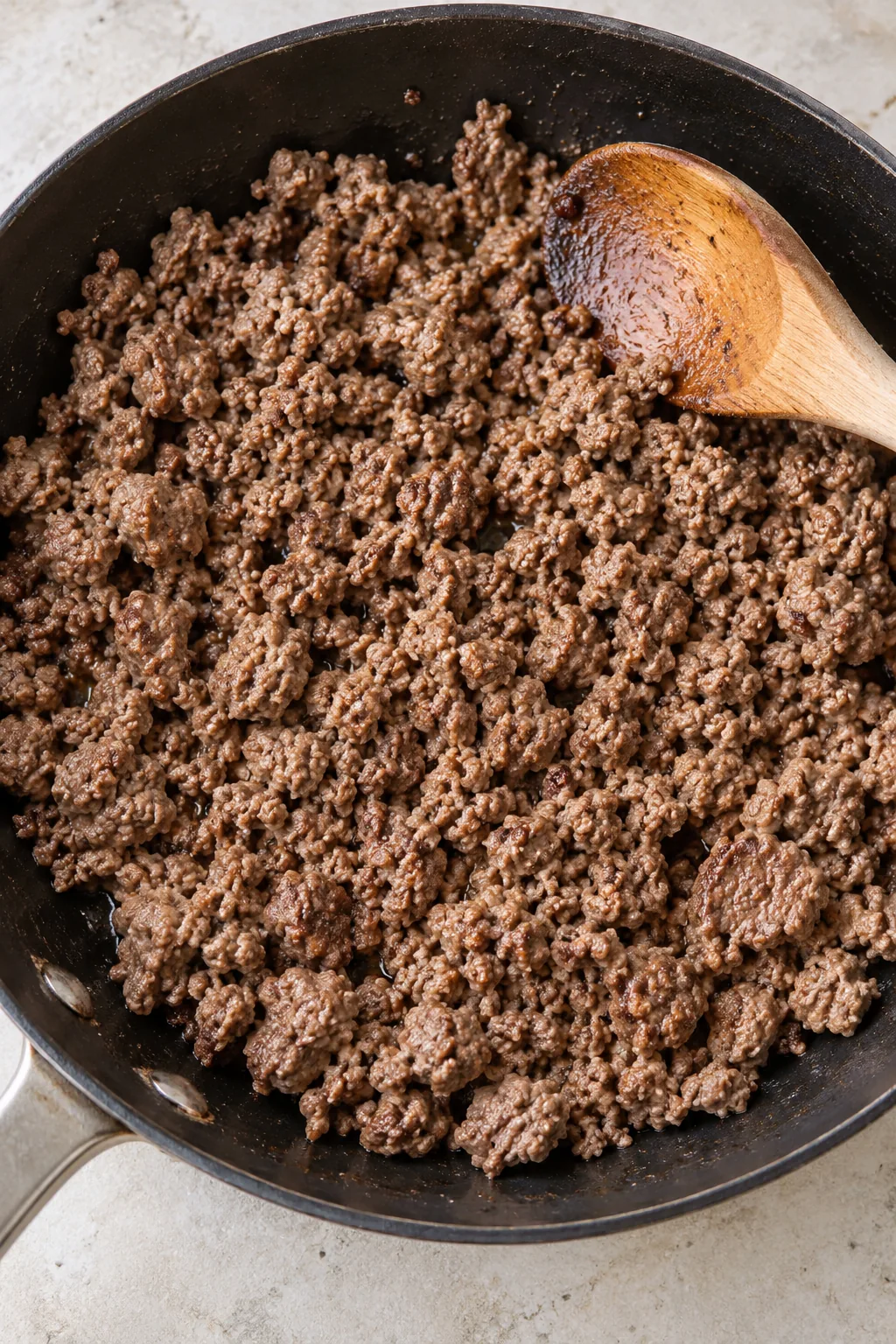 Ground beef browned into small crumbles in a skillet before adding the filling ingredients