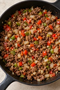 Diced bell peppers and onion softened with browned ground beef.