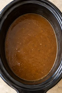Smooth brown gravy in the slow-cooker insert after the beef has been removed