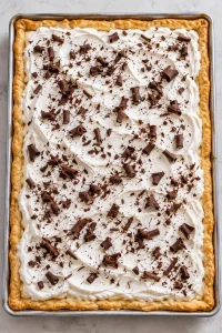 Chilled French silk slab pie finished with whipped cream and chocolate curls.