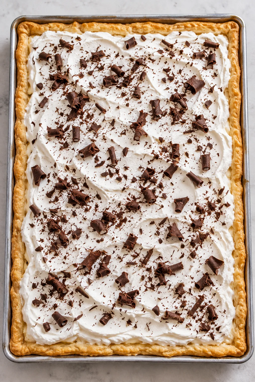 Chilled French silk slab pie finished with whipped cream and chocolate curls.