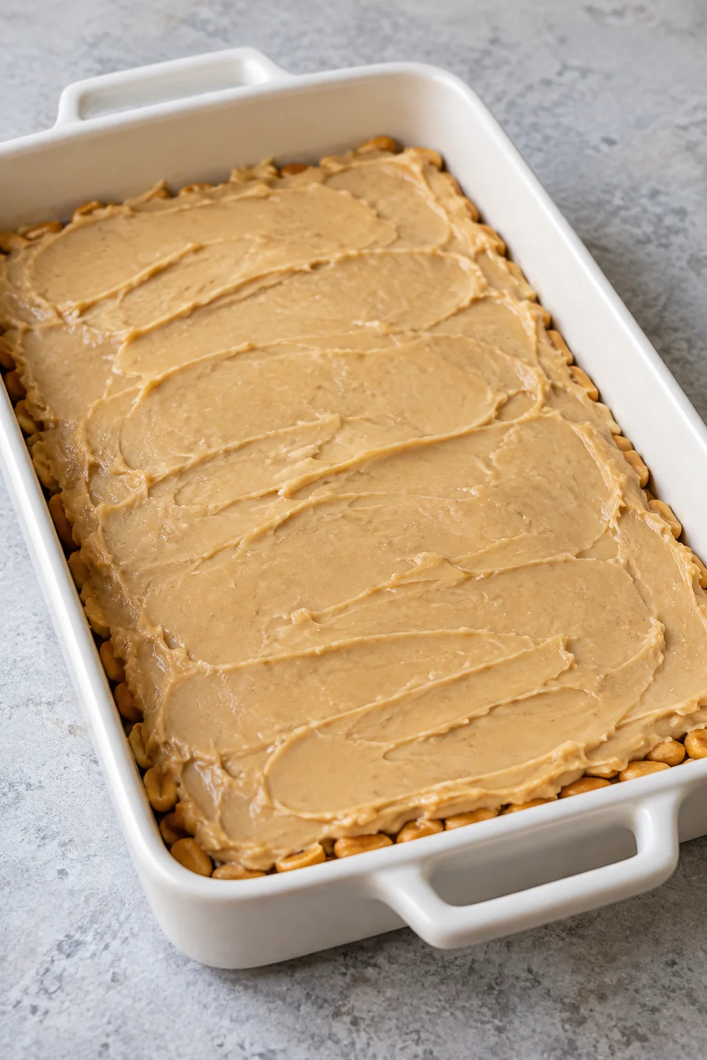 Warm candy filling spread evenly over the bottom peanut layer.