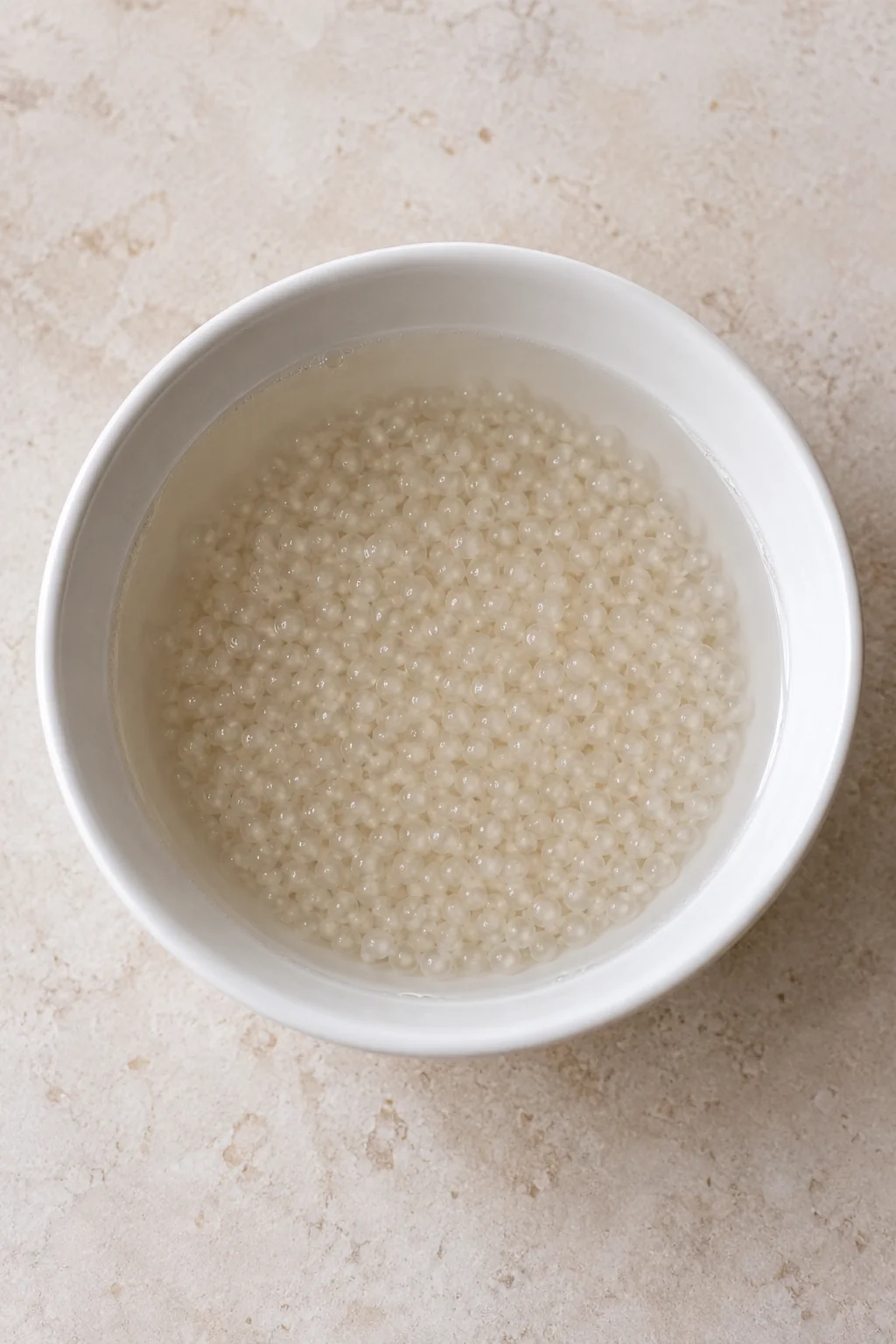 Small tapioca pearls soaking in water before cooking.