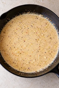 Heavy cream stirred into the garlic and broth to start the pan sauce.