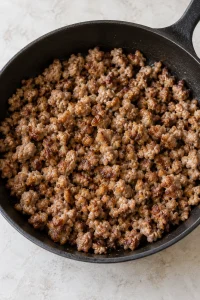 Crumbled breakfast sausage cooked and browned in a plain skillet