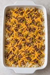 Hash browns, browned sausage, shredded cheddar and diced green chiles layered before the egg mixture is added
