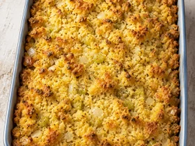 Whole Mama’s Cornbread Dressing with a golden top in a blue baking dish