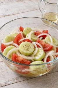 Vinegar dressing added to the cucumber, tomato and onion mixture.