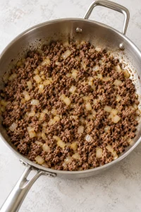 Ground beef and onion browned in a deep skillet
