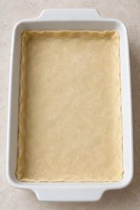 Unbaked pie crust fitted into the bottom of a rectangular baking dish