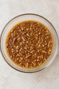 Chopped pecans mixed into the brown sugar and corn syrup filling