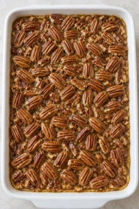 Pecan halves arranged over the second layer of filling before the final bake
