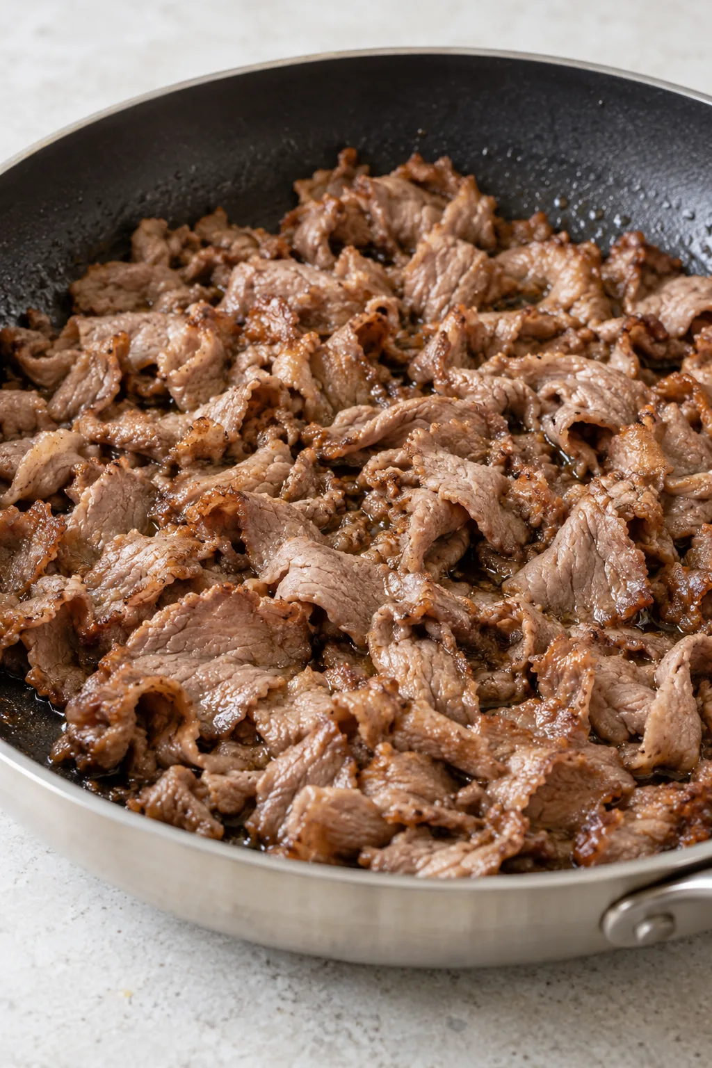 Thin shaved roast beef warmed in a skillet with a few lightly browned edges