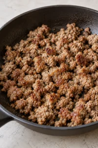 Browned breakfast sausage crumbles in a skillet