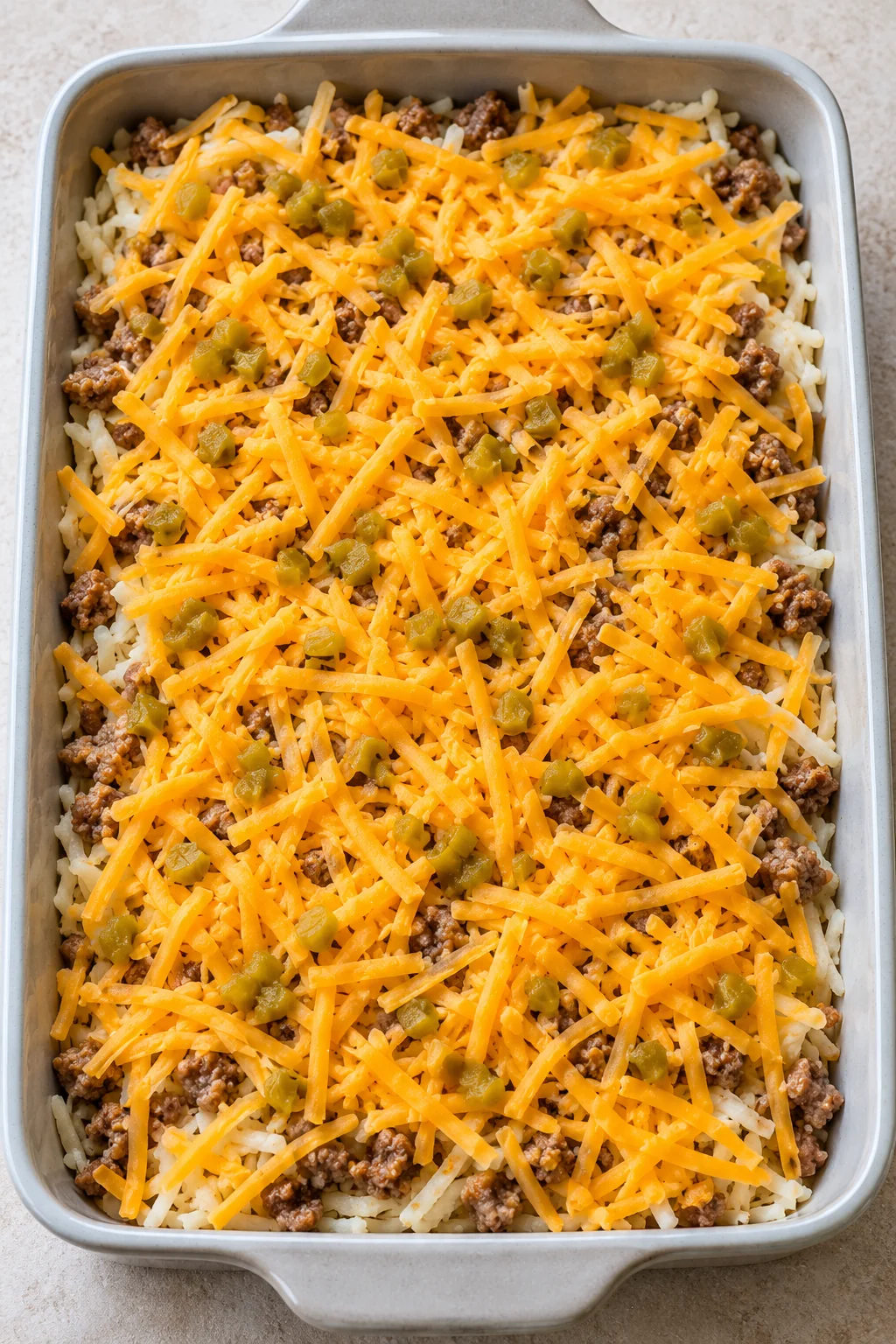Shredded cheddar and drained diced green chiles over the sausage layer