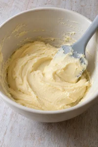 Cream cheese, egg, and vanilla mixed into a smooth filling in a plain bowl