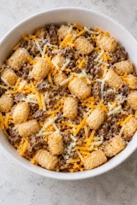 Frozen tater tots gently mixed with cooked sausage, cheddar, and mozzarella